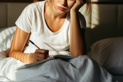 Woman taking notes in bed in the morning