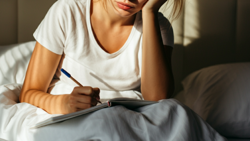 Woman taking notes in bed in the morning